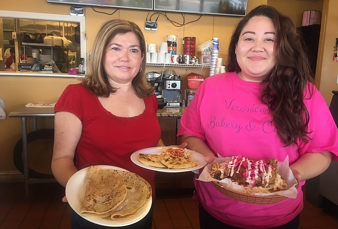 Ana Salinas with daughter Rebeca displaying their popular chicken and tortilla dish at Veronica’s.
