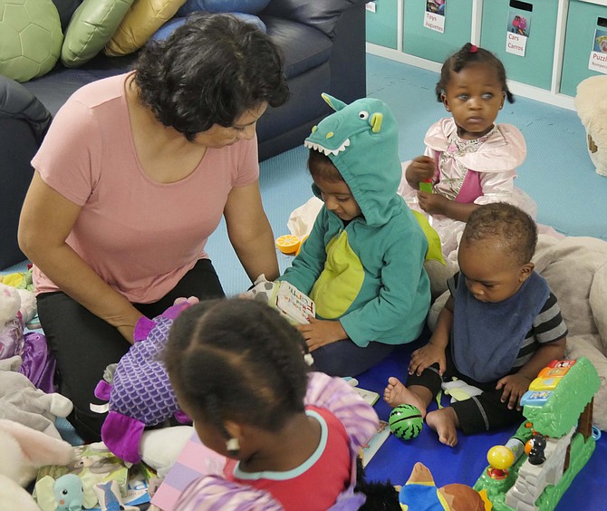 Lilia Crisostomo reads to the four children in her Campagna Center family child care home.