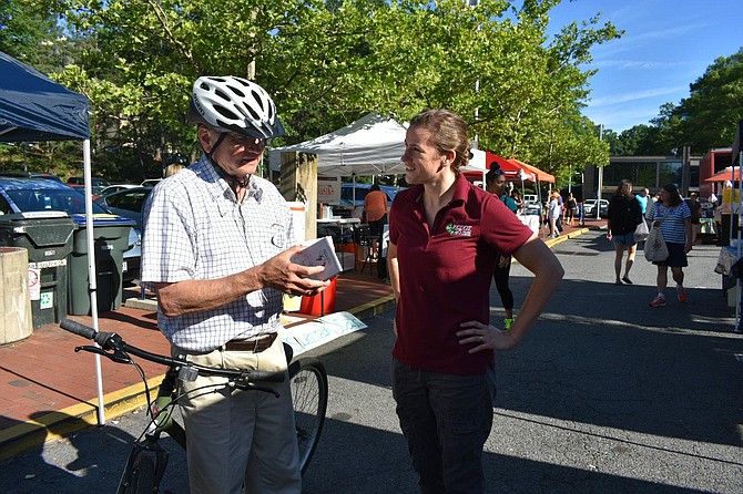 Reston resident Thomas Plevyak receives a bike map from FCDOT Bicycle Program Coordinator Nicole Wynands.