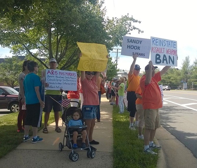 More than 65 activists greet motorists with protest signs Thursday morning, June 14 on their drive past the National Rifle Association headquarters at 11250 Waples Mill Road. Many drivers beep their horns in support.