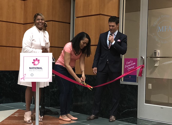 Breast cancer survivor Alessia Saunders, center, cuts the ribbon to officially open the National Breast Center June 12 in Old Town. With her are Tanya Keys of GW Medical Faculty Associates and Dr. David Weintritt, founder of the center.

