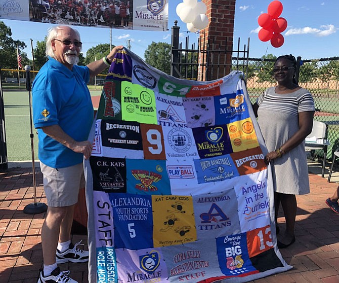 Mac Slover, left, is presented a quilt by Recreation, Parks and Cultural Activities staff member Nadine Brown at a retirement celebration in his honor June 15 at the Kelley Cares Miracle Field. Brown handcrafted the quilt from Slover’s old staff and recreation t-shirts representing his 30 years with the city’s sports department.