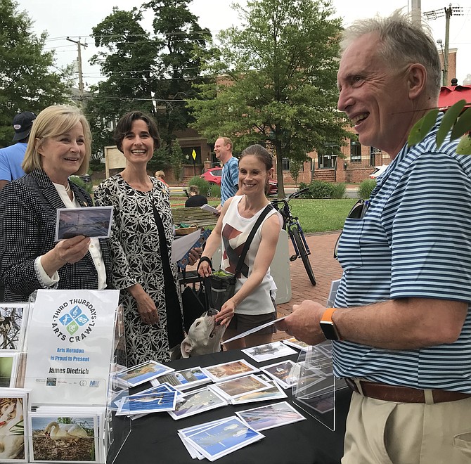 Delegates Kathleen J. Murphy (D-34) and Jennifer B. Boysko (D-86) attend Arts Herndon Third Thursdays Arts Crawl on June 21 and stop by the table of Great Falls Photographer James Diedrich.
