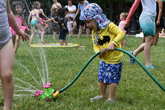 Connor Pollak, 2, plays with a flower sprinkler.