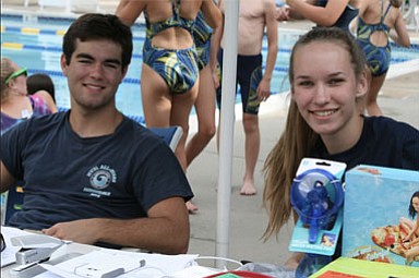 Swim-a-Thon Co-Chairs James Bouharoun, 17, and Maren Kranking, 17, work the check-in table at the event, collecting paperwork and donations to HSC Pediatric Center.
