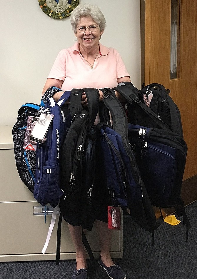 Holding donated backpacks is Jane Copeland of St. Andrew Catholic Church. She’s helped WFCM collect backpacks since 1999, when the church provided backpacks and supplies for 17 students. Last year, she delivered 97 backpacks to Liberty Middle School.