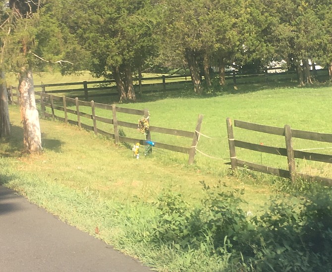 At the crash site on Fairfax Station Road, a part of the fence is missing and a makeshift memorial remain.