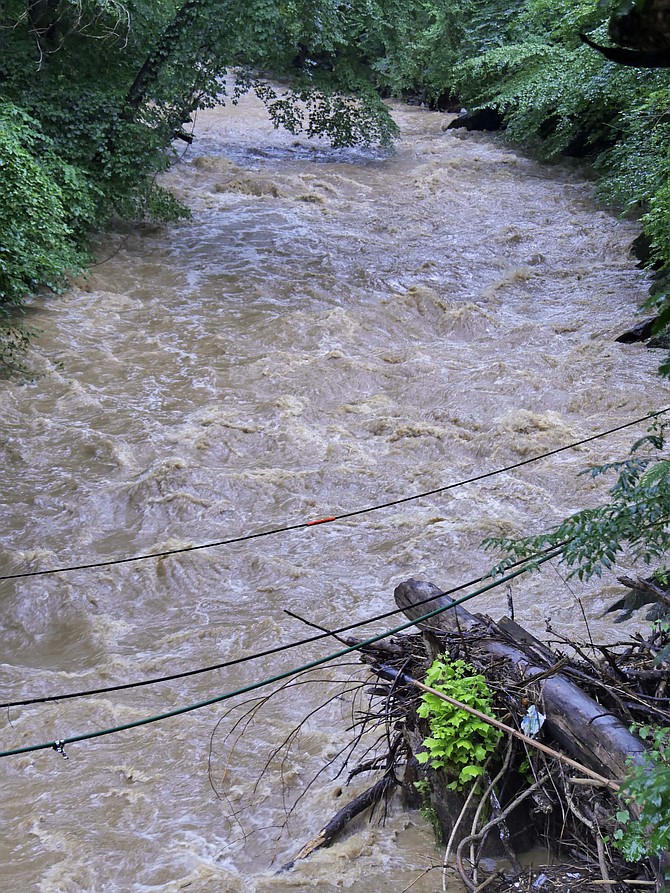 After days of record-breaking rain, the Potomac River rages with downed power lines on the Potomac Heritage Trail at the mouth of Pimmit Run.