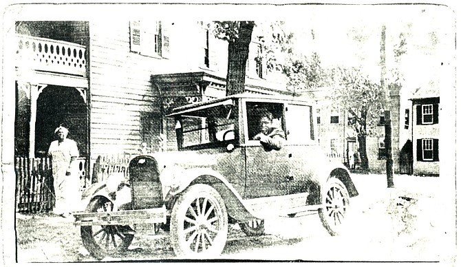 1927 picture of Charles William (CW) Gray in his car in front of his funeral business at 1021 Oronoco Street.