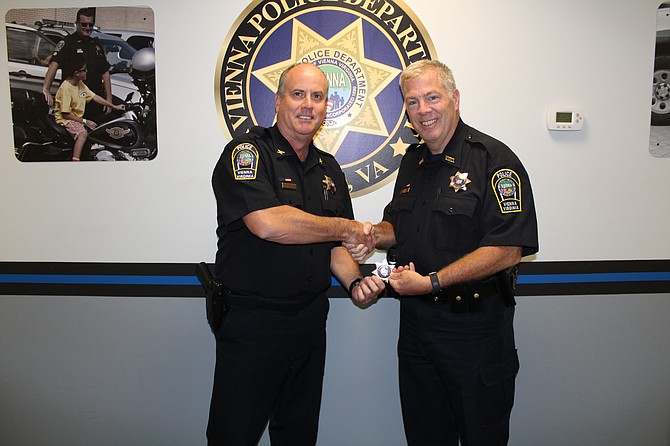 From left: Col. James Morris presenting his badge to Officer John A. Wallace.