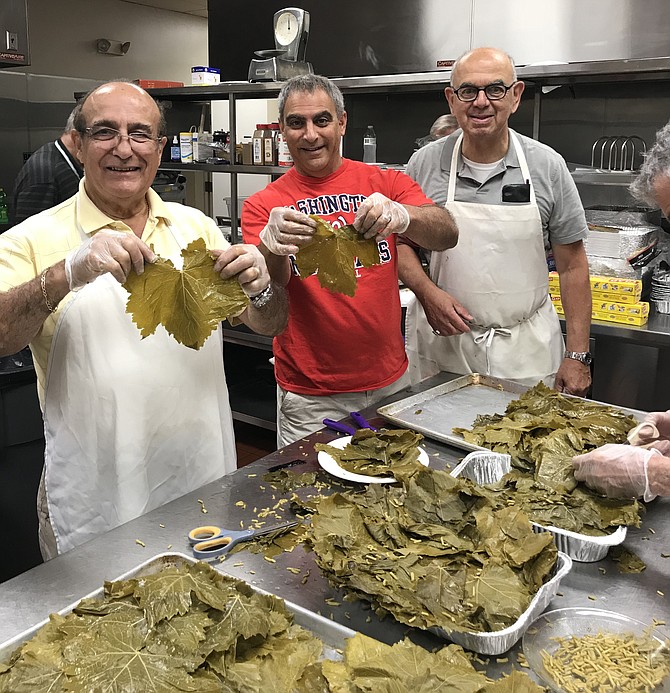 From left: Sam Khalil, Steve Simon and Abe Fanoney prepare grape leaves for rolling.