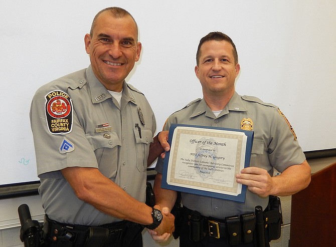 From left: MPO Jeffrey Gregory receives his Officer of the Month certificate from Sully District Station Assistant Commander Ryan Morgan.