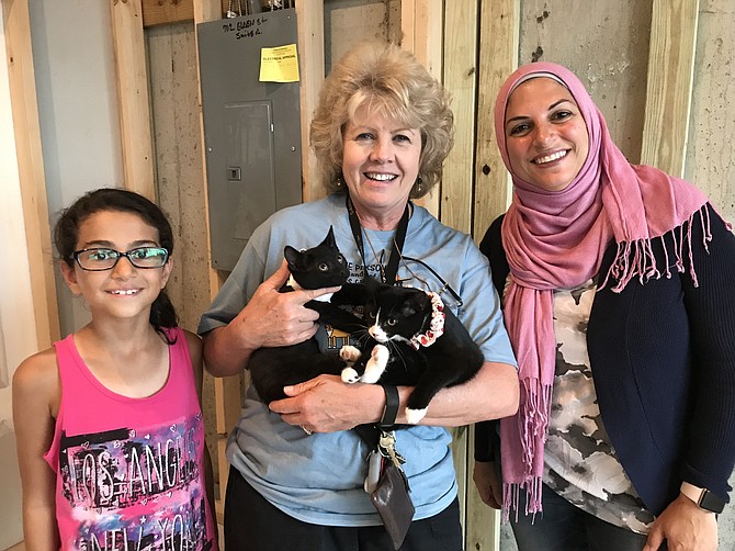 (Center) Christine Cozza from 4 Paws Rescue Team brings a couple of kittens to the future site of Meows Corner, a cat café in Herndon. Dina Abdel-Hamid of Herndon, owner of Meows Corner, and her daughter Mariam Hawa, 8, are excited as the build-out of Meows Corner nears completion.