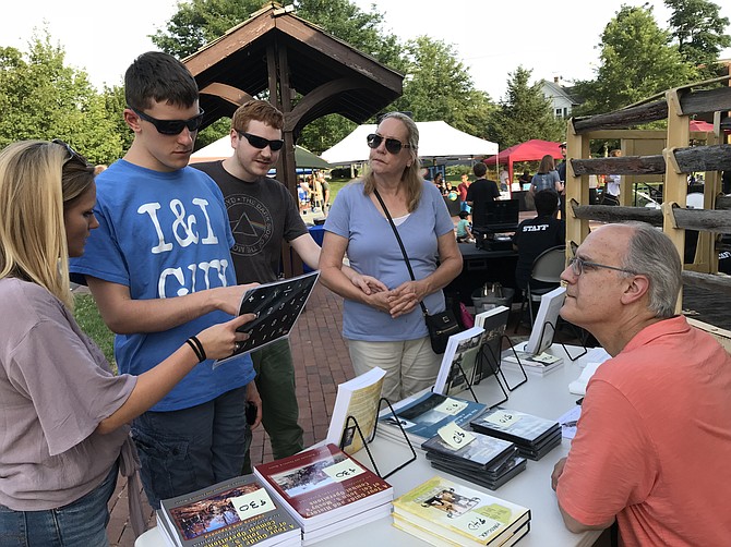 Charles V. Mauro, author of the historical fiction novel, "We Once Met By Chance," awaits the question Thomas Pruyn is posing to him during a book signing. Jessie Bond, Pruyn's communication partner, Ian Nordling and Rosaleen Presley, Ian's mother and communication partner listen. Presley shares Pruyn and Nordling use a letterboard spelling to communicate.