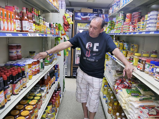 Gabriel Delcid points to Peruvian peppers, one of the many specialty items from Central and South American countries available at La Union Grocery.