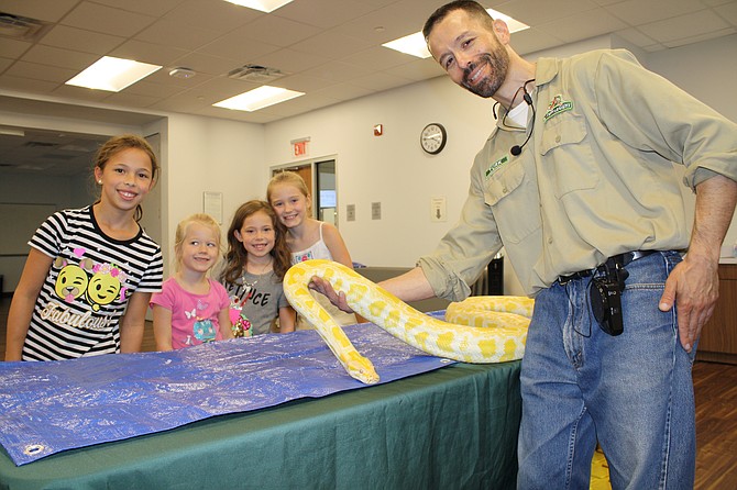 The albino python is hit with Reagan Silver, Harper Gillespie, Lilly Silver and Jillian Gillespie and handler Turk Ozerol of My Reptile Guys.