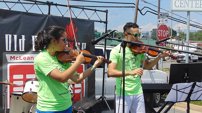 Violin duo Julia and Yousif Hakeem performs. Julia organizes the bike collection at James Madison High School.