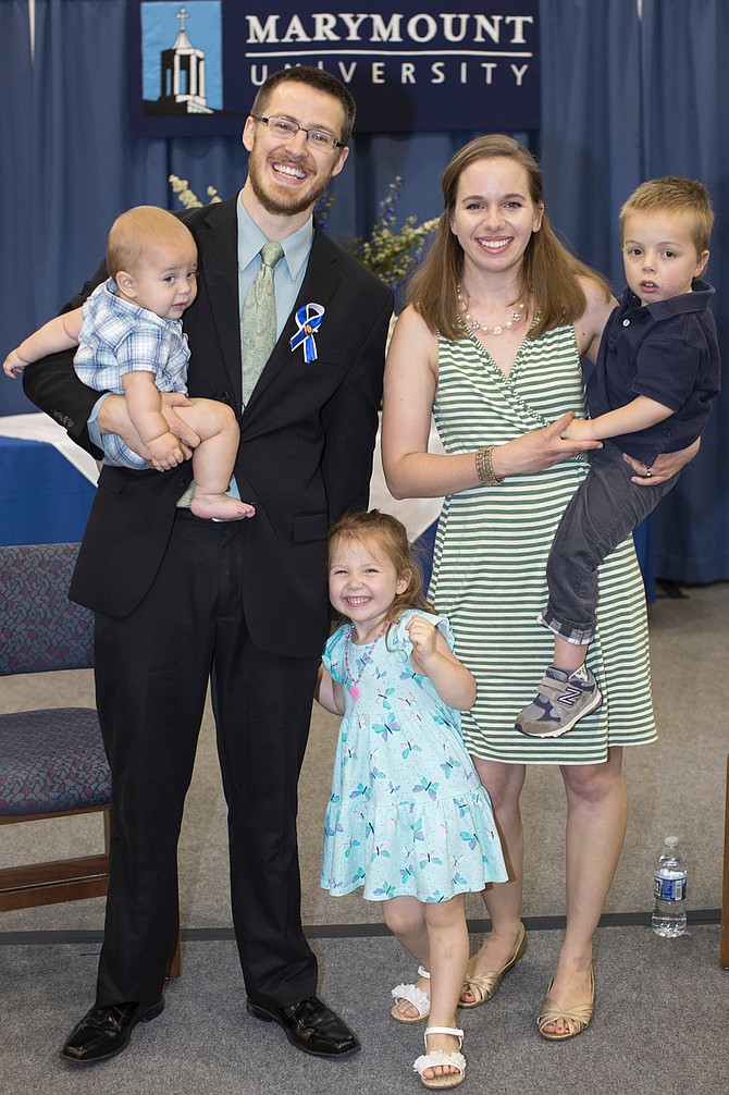 Adam Mann with his son, Caleb, 8 months, Isaac, age 5, wife Lauren, and Lydia, 3, following his pinning ceremony speech.