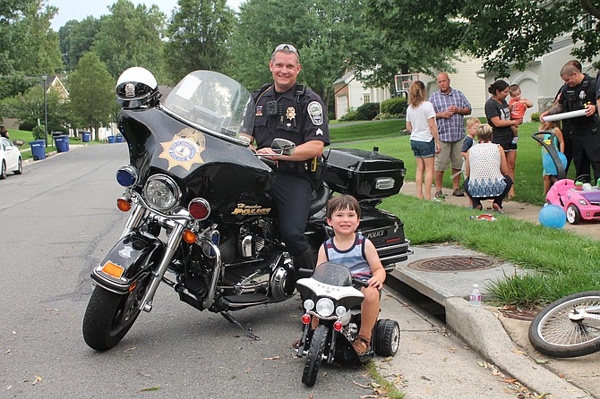 It’s kickstand down for Sergeant Jim Rider of Herndon Police Department as he pulls up alongside his future replacement during National Night Out 2018 in the Town of Herndon.
