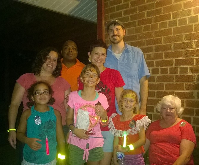 The spirit of this year’s National Night Out block party is captured on the front porch of Bren Mar resident Sue Hotto, seated far right.  Back row:  Lisa Wesley, her husband, Bey Wesley, Bonnie Robinson and her husband, Lenny Bankester.  Front row:  Eva Wesley, Sylvie Bankester, Melody Bankester and Hotto.  