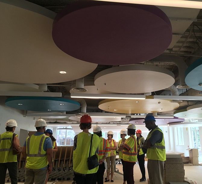 City and school employees tour the first floor cafeteria. The setup, once complete, will include small tables for a “family feel,” said Principal Rachael Dischner.
