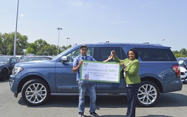 Santos Matute (left) receives the keys to his new vehicle from Vivian Mitchell of the Virginia Lottery.