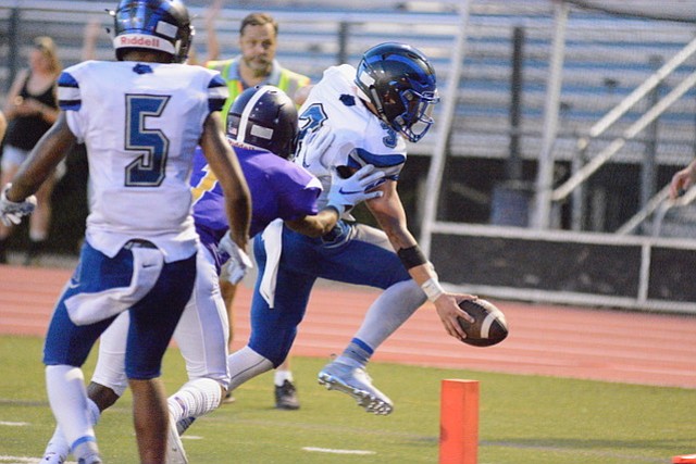 West Potomac quarterback JT Mayo reaches the ball over the goal line for one of his three rushing touchdowns against Lake Braddock on Aug. 31.
