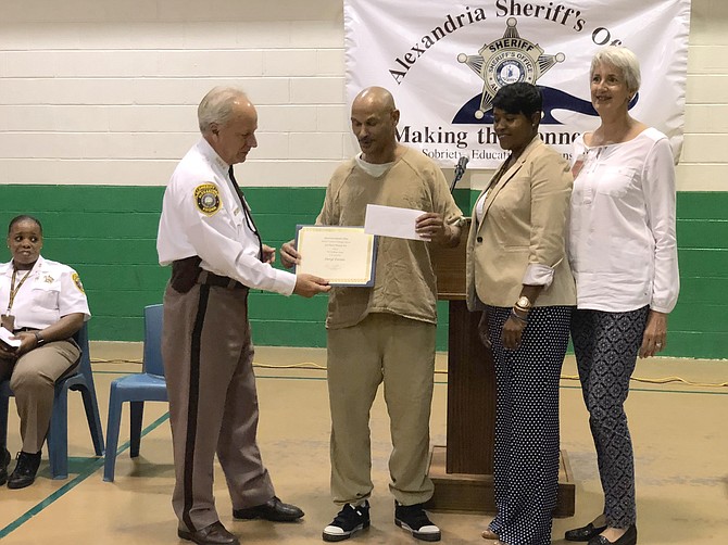 Sheriff Dana Lawhorne, left, presents the third place poetry award to Daryl Torien at the Aug. 16 HEARDS Creative Writing Awards ceremony at the William G. Truesdale Detention Center. With Lawhorn and Torien are Gloria Wright, director of inmate services, and HEARD founder Jane Collins.
