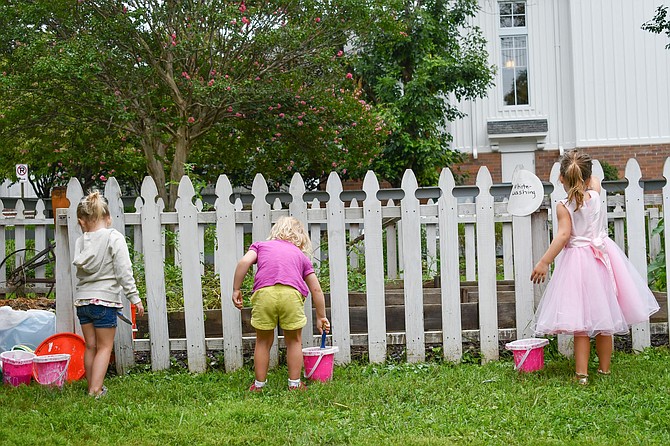 Three young girls whitewash the fence surrounding the Great War Garden. Children’s activities were provided throughout the day.