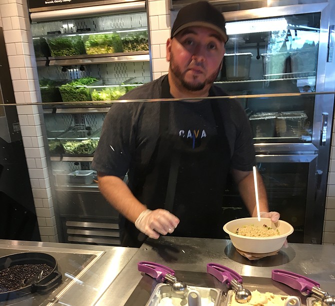 Manager Abel Vena creates a bowl for a customer at CAVA in Cabin John Village Saturday. The restaurant, at the corner of Seven Locks and Tuckerman roads, opened Aug. 8. 