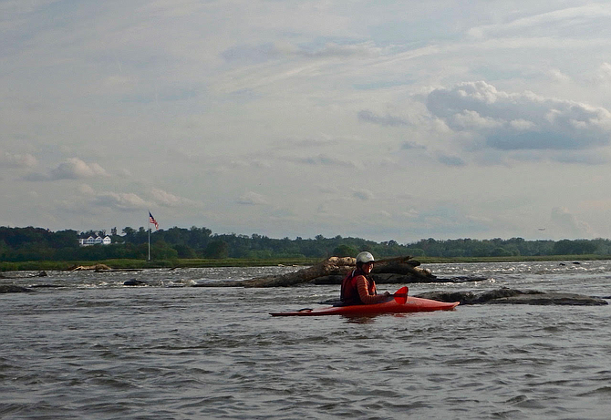 A kayaker on the Potomac River at Seneca. In the background is Trump National Golf Club, Great Falls, Va. The Coast Guard closes the river when President Trump or "high ranking United States officials" are using the club.