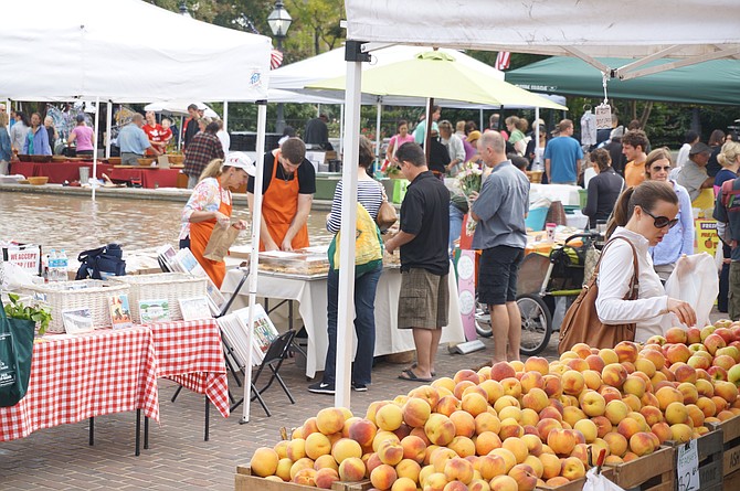 Shoppers enjoy the Old Town Farmers Market in Market Square. Visit Alexandria announced Sept. 24 that visitor spending in Alexandria grew to a record $826 million last year, a $36 million increase from the previous year.