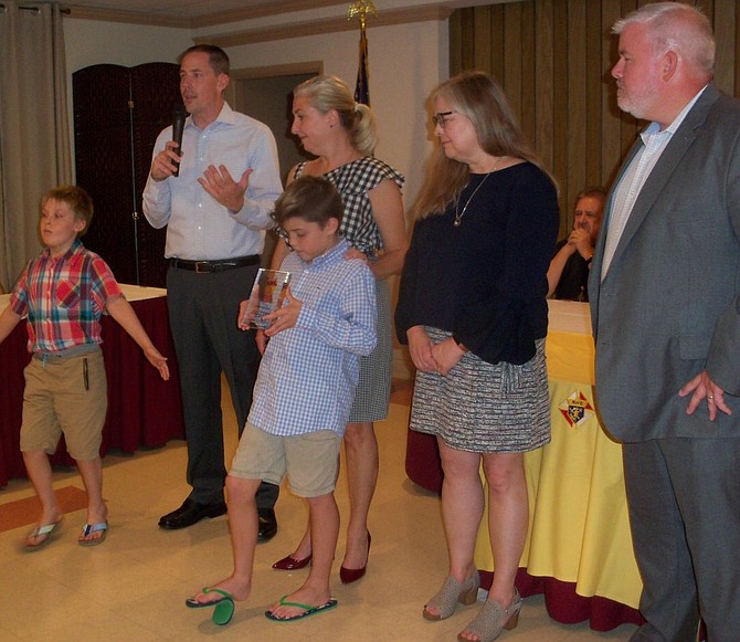 In front, Joseph Miller and James Miller hold the appreciation award conferred by Tracy’s Kids to Edward Douglass White Council 2473, Knights of Columbus. In back, parents John and Teresa Miller; Tracy Councill, founder of Tracy’s Kids; and Bryant Porter, chairman, Derby Day Party. 