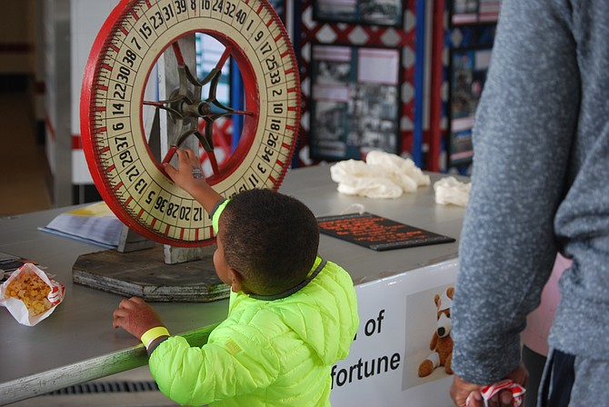 Child spins “The Wheel of Misfortune,” a new game at the Great Falls Volunteer Fire Department. Kids learned what to do given a specific emergency situation.