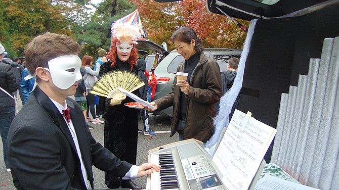 John Nothaft, director of music, with Sally McKeown, choir member, and Yuko Takakusaki, caroler, with their “Phantom of the Opera”-themed car.