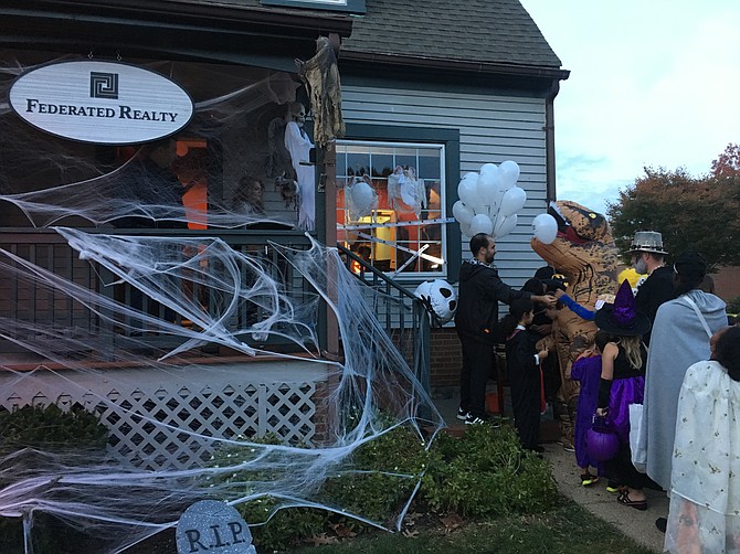 Dinosaurs, witches, and many other characters lined up outside of the Federated Realty office on the Green to get candy and balloons.