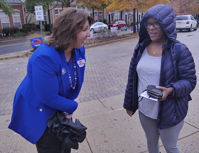 Novlie Evans talks with City Council candidate Amy Jackson. Jackson says, "It's been busy at all of the polling places where I've been today. There has been a steady stream of rain and voters. That's good for the Democrats."