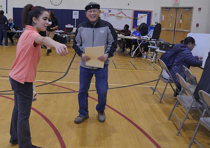 Layla Janah, a Moroccan student in T.C. Williams International Academy, serves as an election page at Samuel Tucker Elementary School polling place.