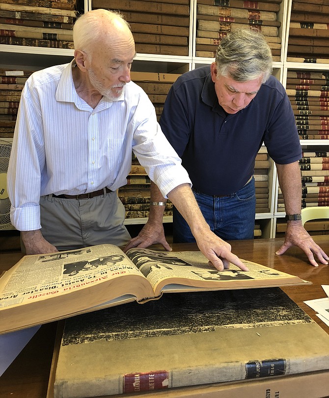 Researcher Michael McMorrow, left, and Friends of Rocky Versace organizer Kevin Rue, review the obituary records of local veterans killed in the Vietnam War, in the Alexandria Gazette Packet offices Oct. 31.