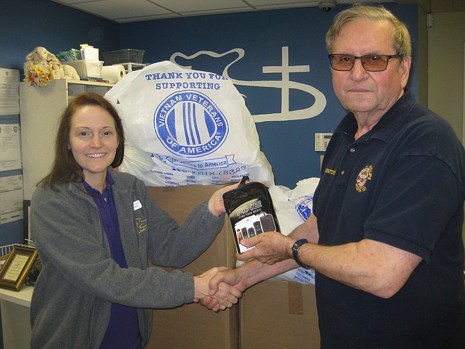 Len Ignatowski, Vietnam Veterans of America (VVA) Chapter 227 Vice President, delivers travel-size toiletries to Doris Paul, Volunteer Manager of The Lamb Center in Fairfax City, as part of the chapter’s continual community and veteran outreach.