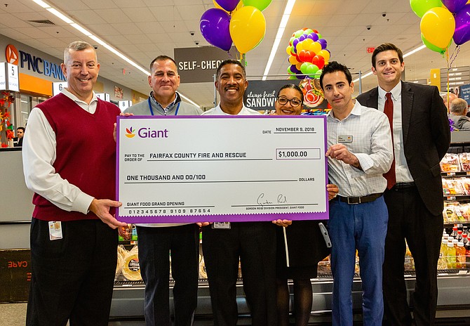 From left, Giant Food Regional Vice President Robert Belcher; District Director Jeff Lewis; Battalion Chief Willie F. Bailey of the Fairfax County Fire and Rescue Department; Felis Andrade, Director of External Communications and Community Relations; Store Manager AJ Rashad; and Daniel Wolk, Coordinator of External Communications and Community Relations; hold the donation check presented to Fairfax County Fire and Rescue at the Grand Opening of the Herndon Giant at 2425 Centreville Road.