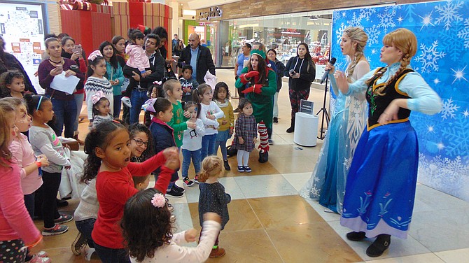 “Anna,” aka Lizzie Allen, and the “Frozen Queen,” aka Jenepher Esser, of The Princess Performers delight the crowd during the Santa Fest at Springfield Town Center.