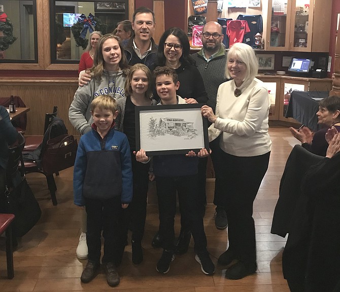 The Beebe Family receives an original pen and ink sketch of their home created by acclaimed artist Pat Macintyre (right front) who also serves as Vice President of the Board for Arts Herndon. Homes Tour Committee Co-chair, Keven LeBlanc, (right back) joins in.