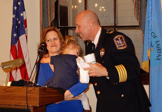 Cathy and Carl Pardiny with sleepy granddaughter Sydney, 2½, during the ceremony.