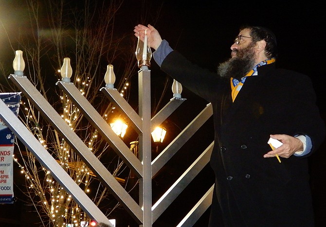 Rabbi Sholom Deitsch lights the Chanukah menorah in Old Town Square.