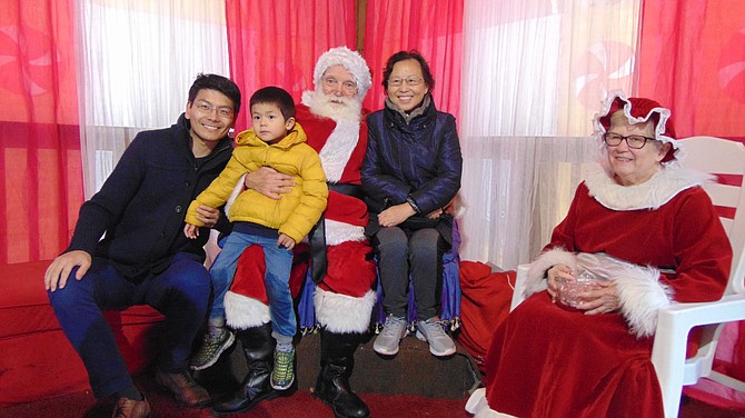 Zhengia and Winston Meng and Xiao Lan Cheng of Vienna visit Santa and Mrs. Claus, a.k.a. Rodney and Janet Smith.