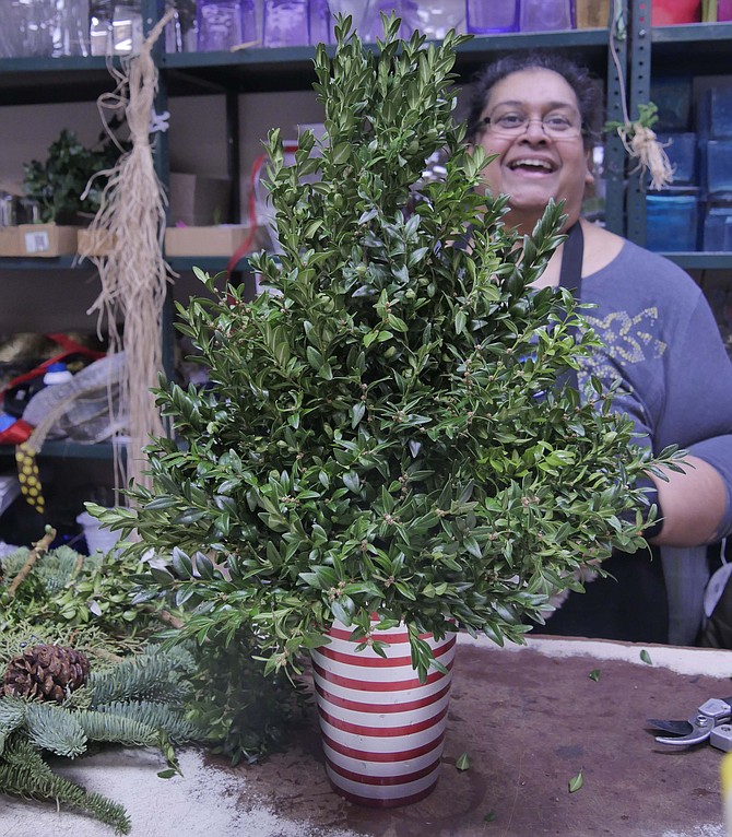 Shakeela Doskas has completed the greenery on her centerpiece and proceeds to the final stages.