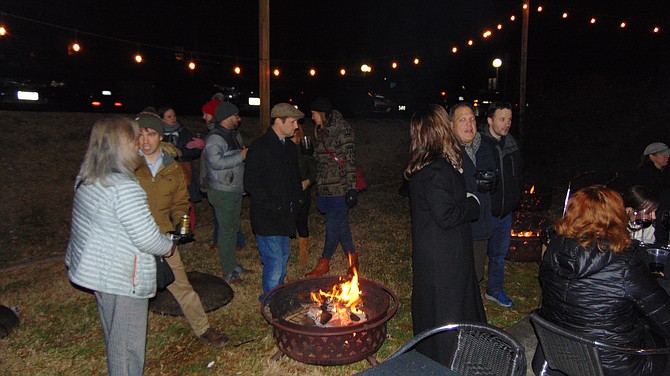 The guests gather around the fire pit during the Toy Drive Holiday Gathering at DRP Belle Haven.