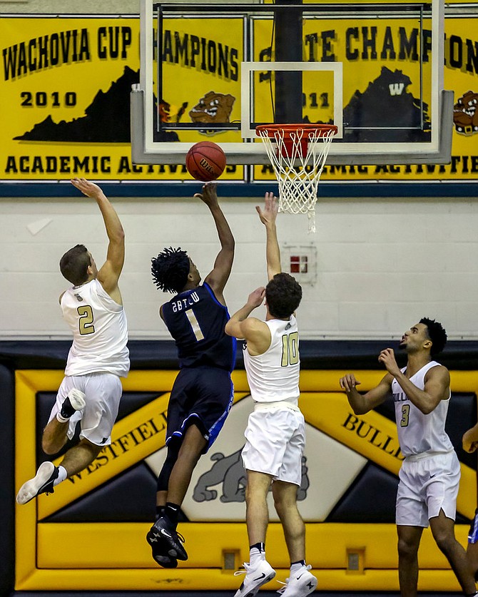 Josh Abtew #1, who led Fairfax with 18 points, tries to avoid Westfield’s Taylor Morin #2 and Kamran Zahory #10.