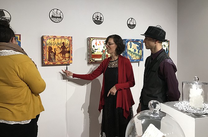 Artist Melanie Kehoss explains her work to patron Jennifer Biehl as Kaveh Jorab looks on during the opening of the exhibit, “Mary B. Howard Invitational: Stretch,” now through Feb. 9, 2019.